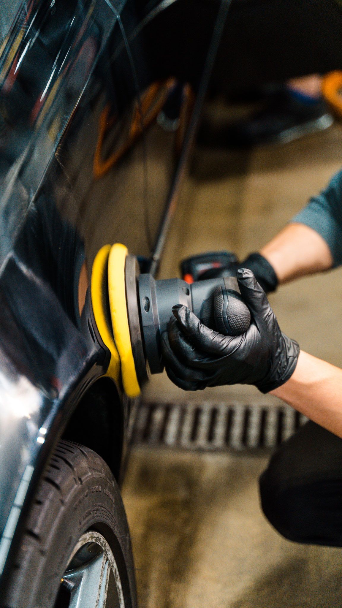 A person is polishing a car with a machine.