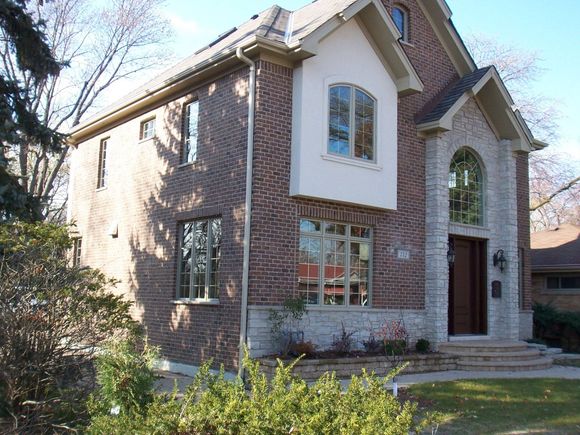 A brick house with a white trim and arched windows