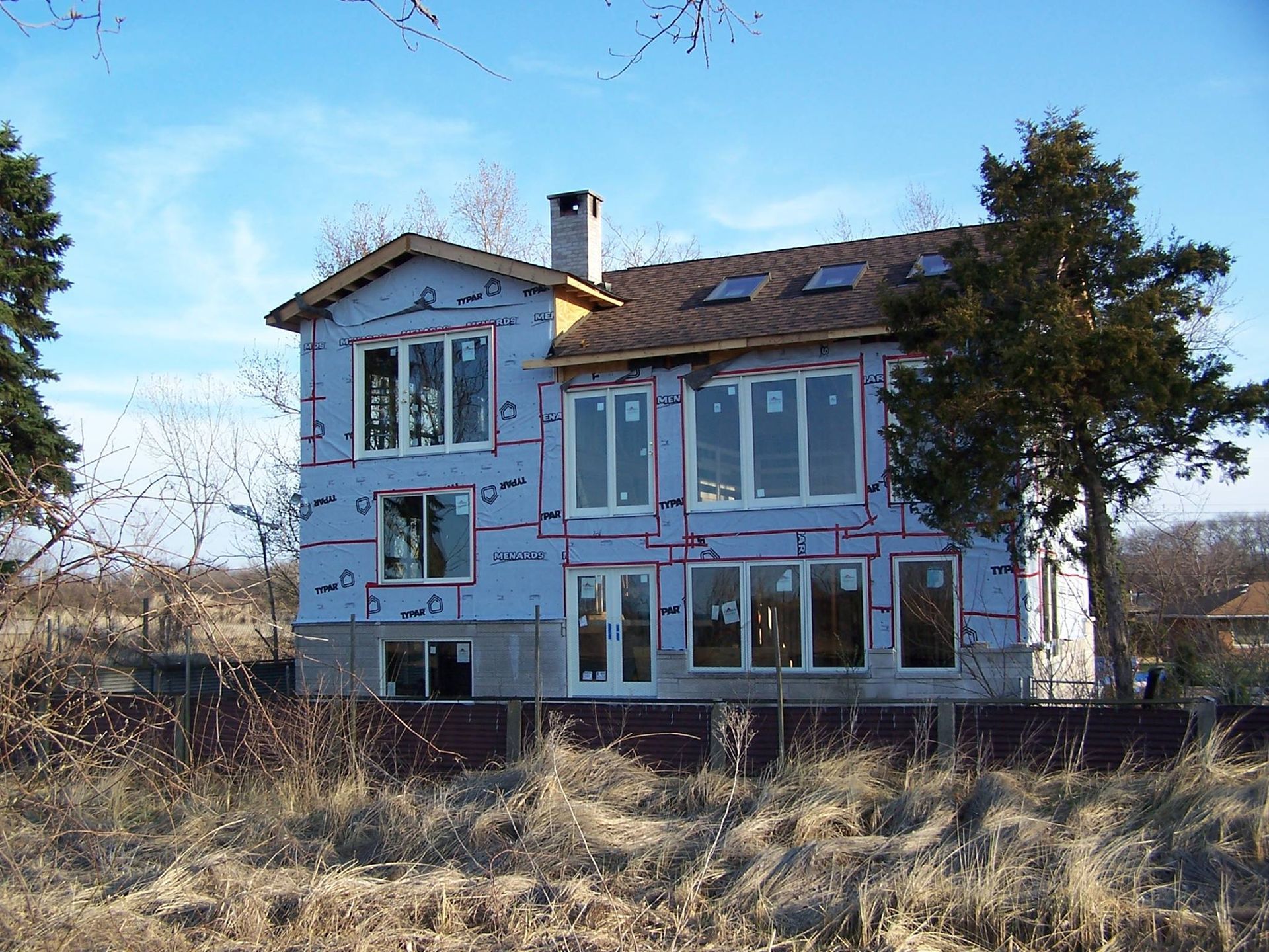 A large house with a lot of windows is being built