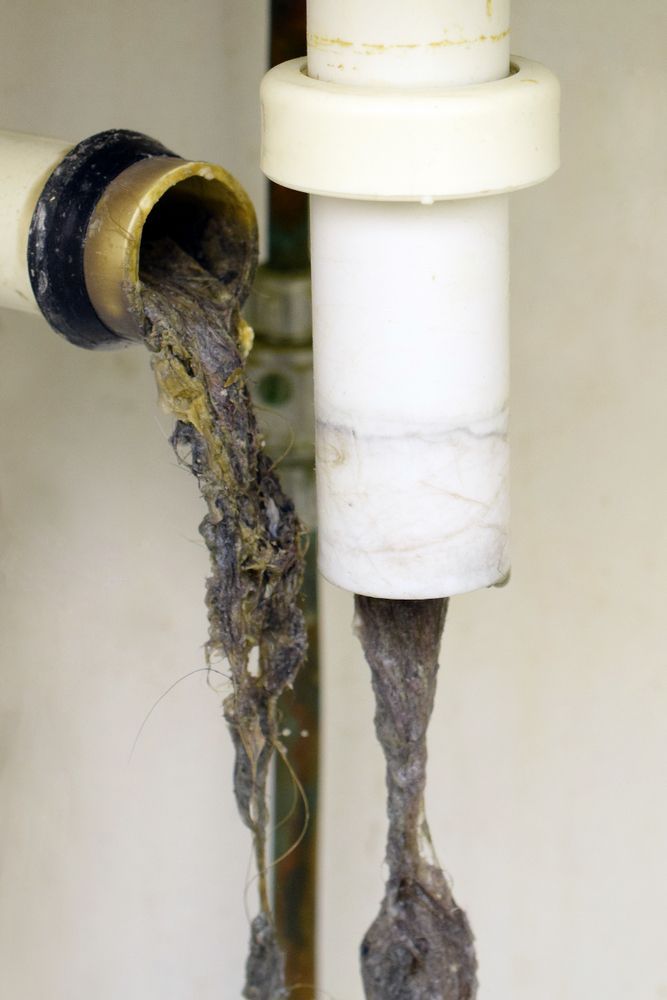 A Drain Pipe With a Lot of Dirty Water Coming Out of It — Hoges Plumbing In West Wollongong, NSW