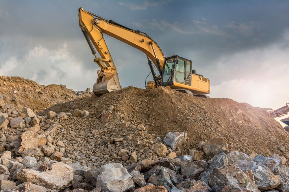 A Construction Worker is Digging in the Dirt With a Shovel — Hoges Plumbing In West Wollongong, NSW