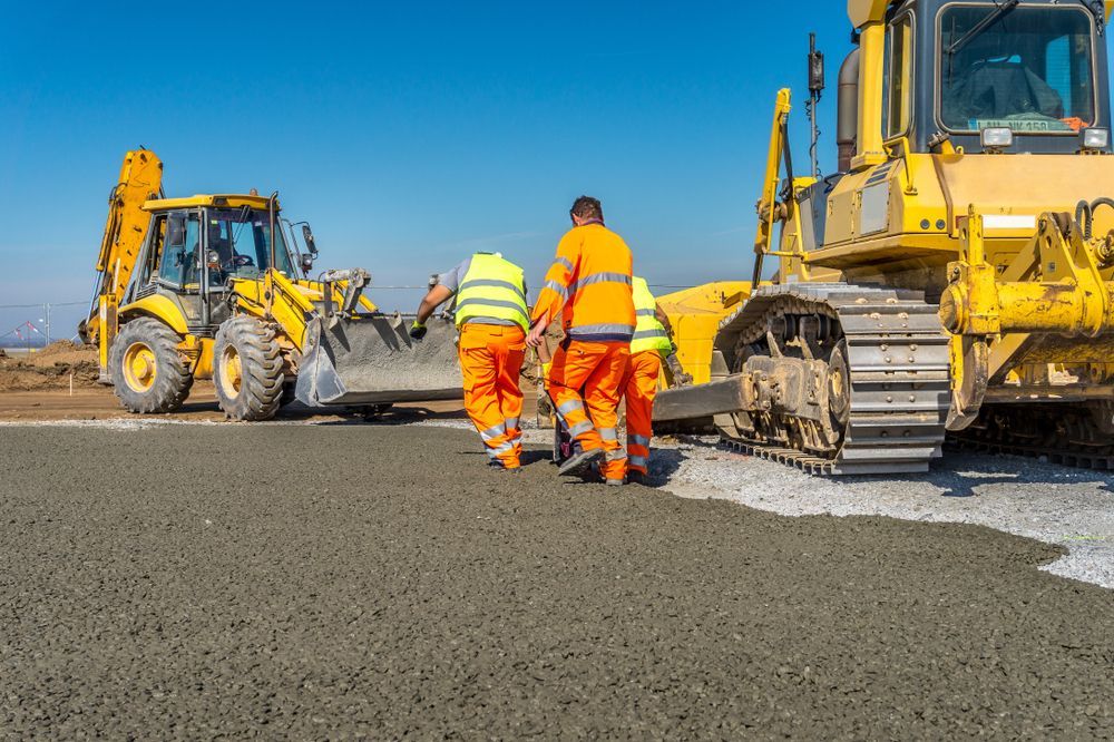 A Group of Construction Workers Are Walking Towards a Bulldozer — Hoges Plumbing In West Wollongong, NSW
