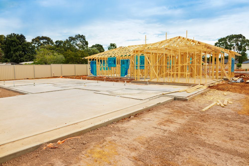 A House is Being Built in the Middle of a Dirt Field — Hoges Plumbing In West Wollongong, NSW