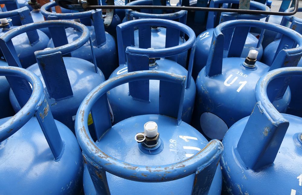 A Bunch of Blue Gas Cylinders Are Lined Up in a Row — Hoges Plumbing In West Wollongong, NSW
