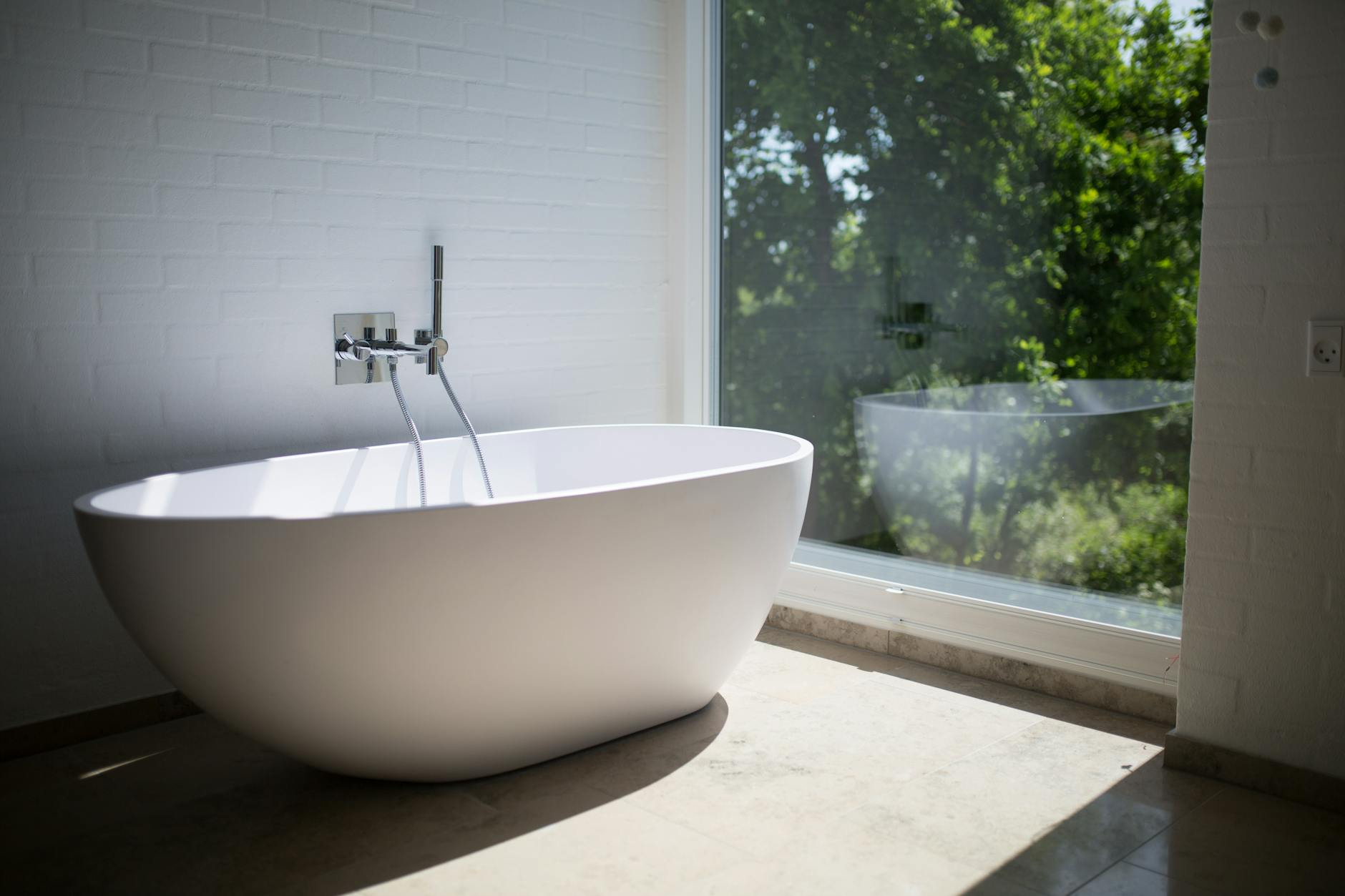 A Bathtub is Sitting in a Bathroom Next to a Window — Hoges Plumbing In Albion Park, NSW
