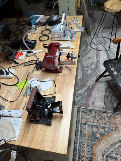 Worktable with power tools, cords, and small parts scattered across a workshop floor