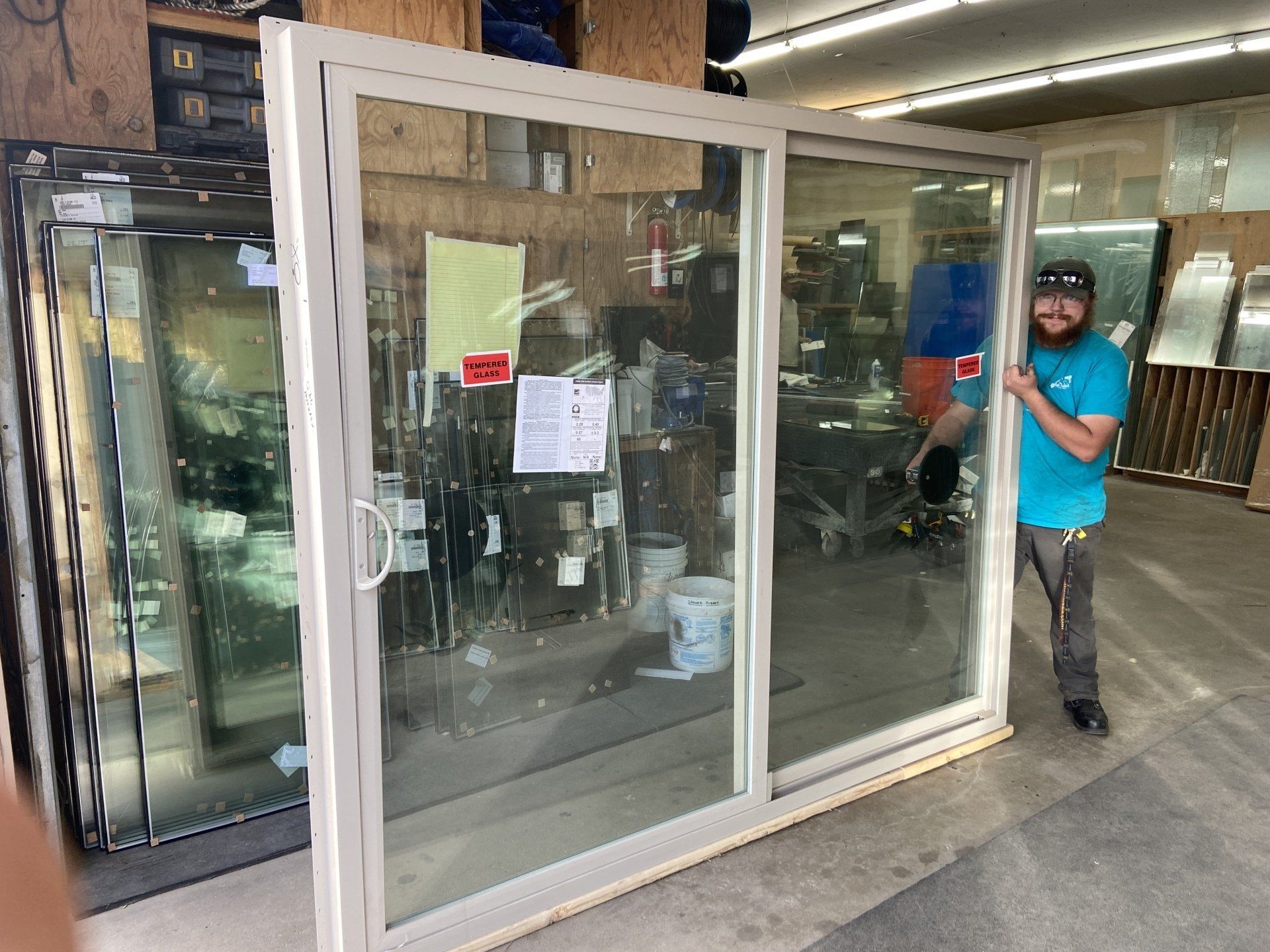 A man is standing in front of a sliding glass door in a store.