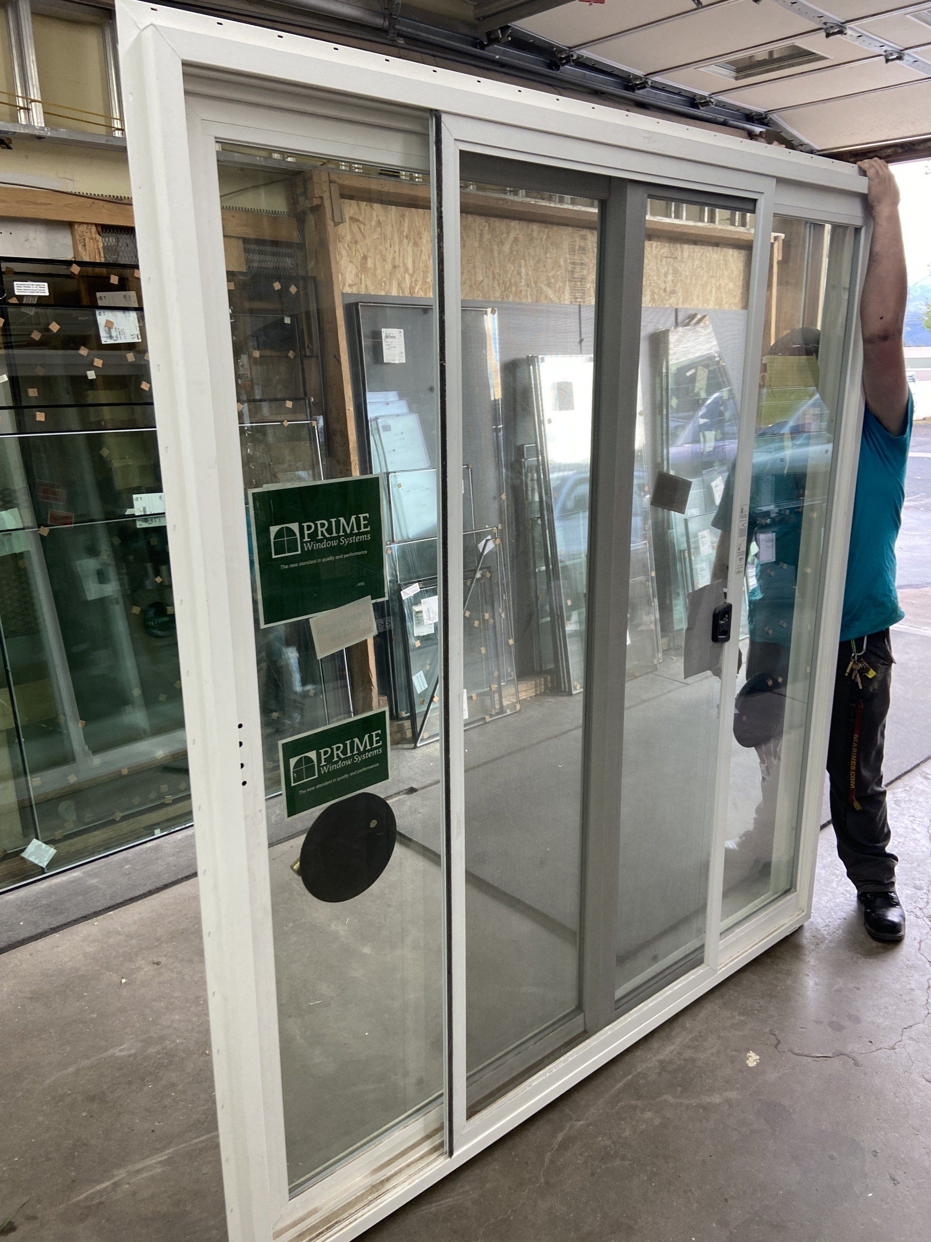 A man is carrying a large sliding glass door.