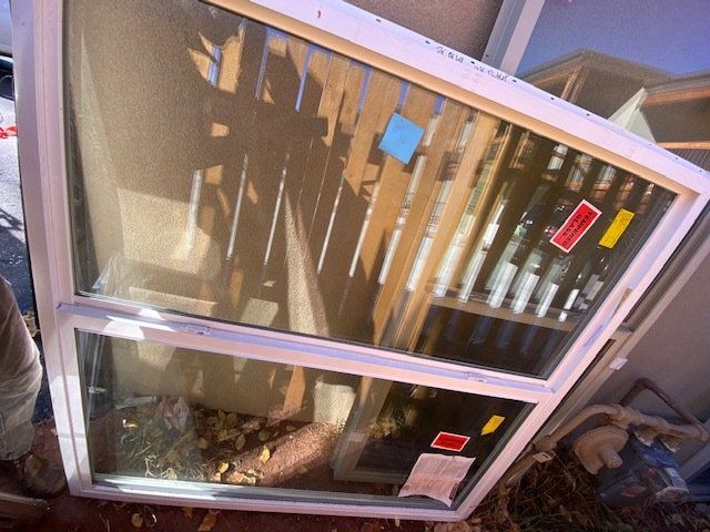 A white window with a reflection of a fence in it