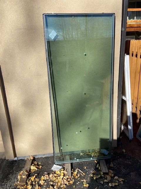 A large glass window is sitting on a wooden stand in front of a wall.