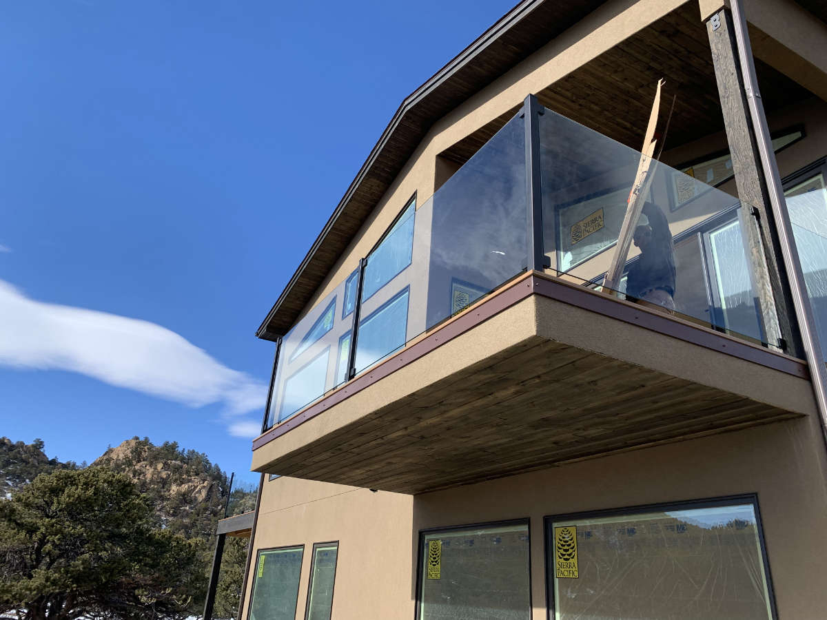 A house with a balcony and a mountain in the background.