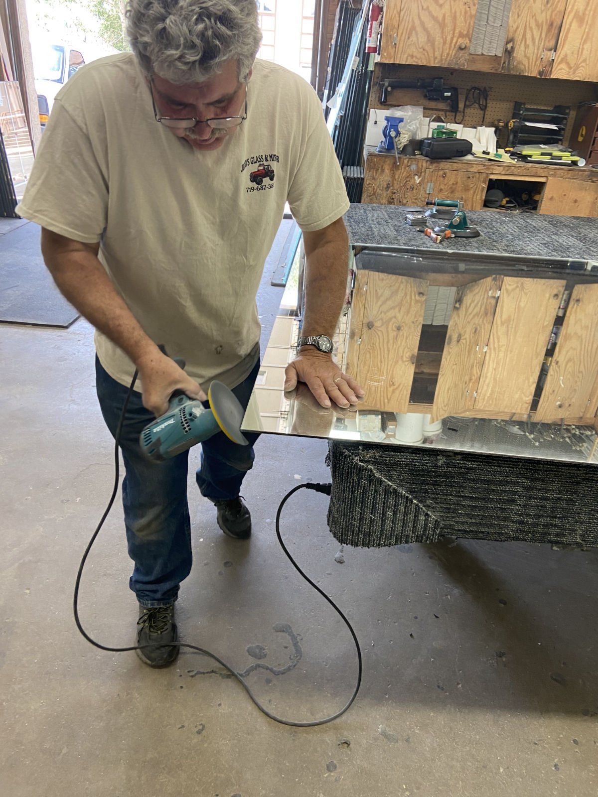 A man is using a grinder on a piece of wood.