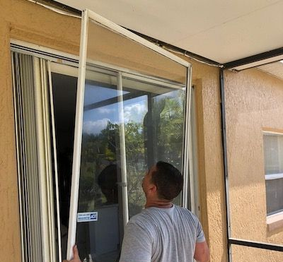 Person installing a screen door on a sliding glass door.