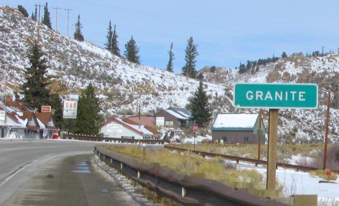 A green sign on the side of a road says granite