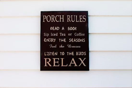 A black sign on a white wall lists 