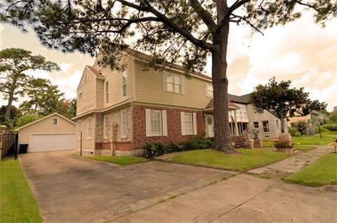 Two story house with driveway going around it to garage in back