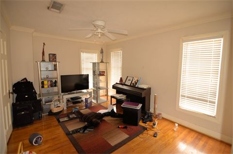 Room with hardwood flooring, ceiling fan, and 3 windows