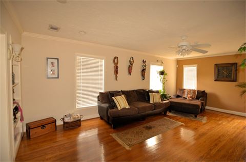 Living area with hardwood flooring and a ceiling fan