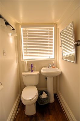 Narrow bathroom with sink and toilet right next to each other
