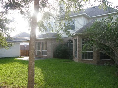 Two story house with brick on front and green grass in yard