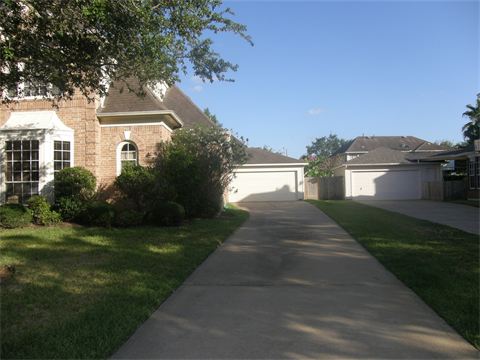 Driveway leading around site of house to a garage