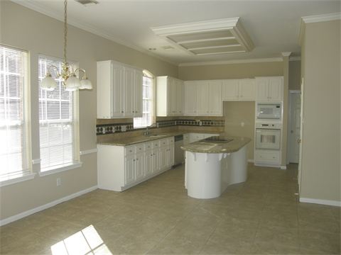 Kitchen with white cabinets and dining room next to it