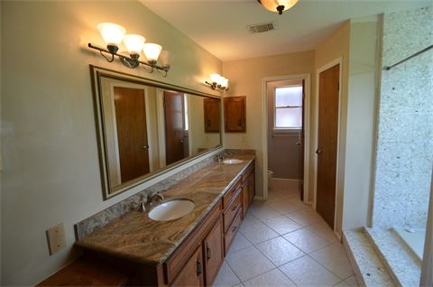 Bathroom with tiled floor and two sinks in vanity