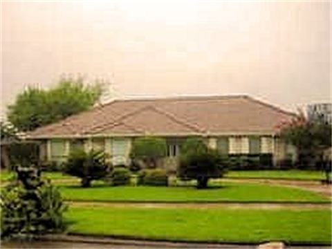 House with green grass and landscaping in front yard