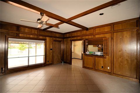 Room with tiled floor and wood paneling on walls