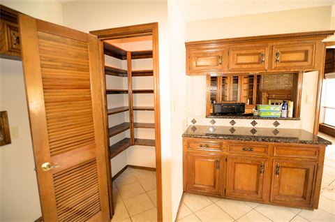 Pantry with open door and counter top next to it