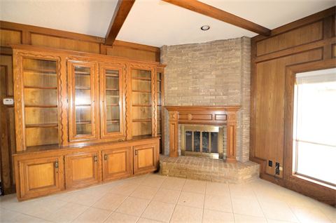 Room with fire place and finished wood cabinets