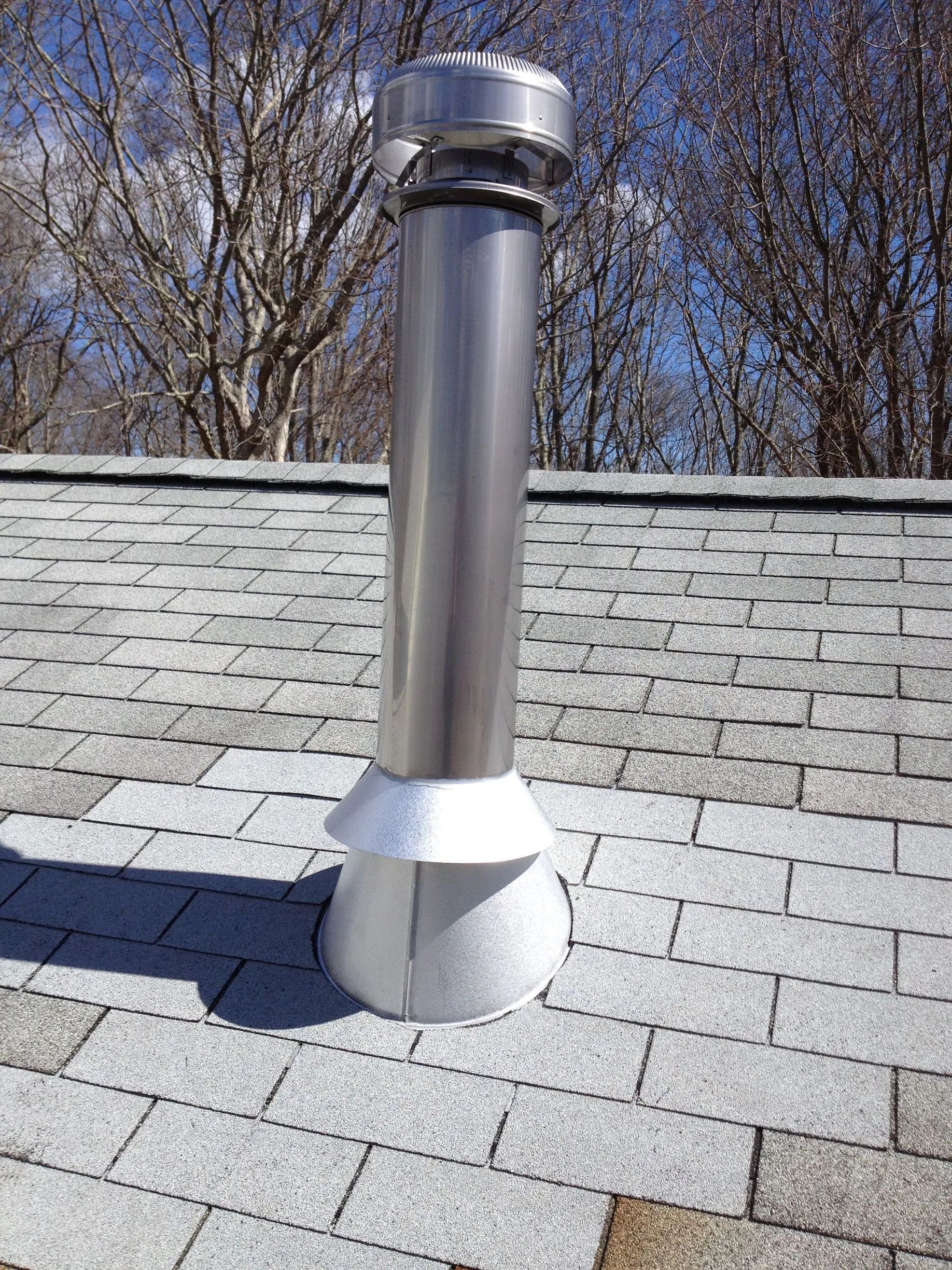 A stainless steel chimney is sitting on top of a roof.