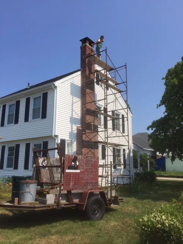 A man standing on a scaffolding next to a house.