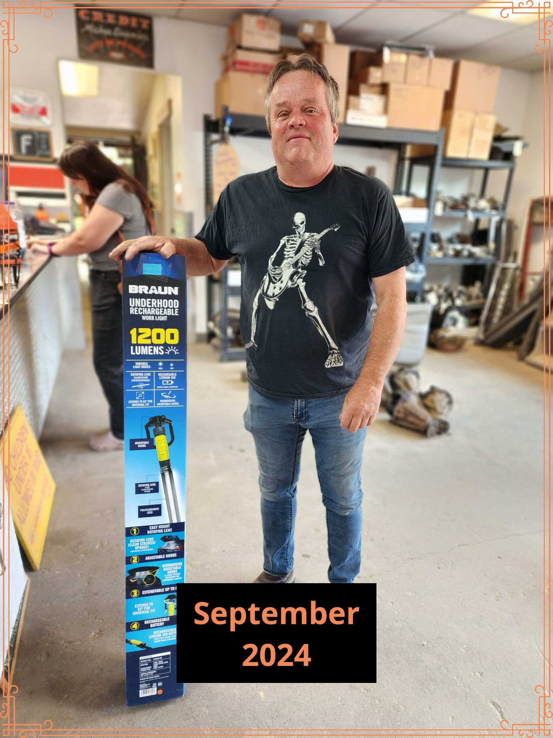 Man holding a product in a store, September 2024, with a woman in the background.