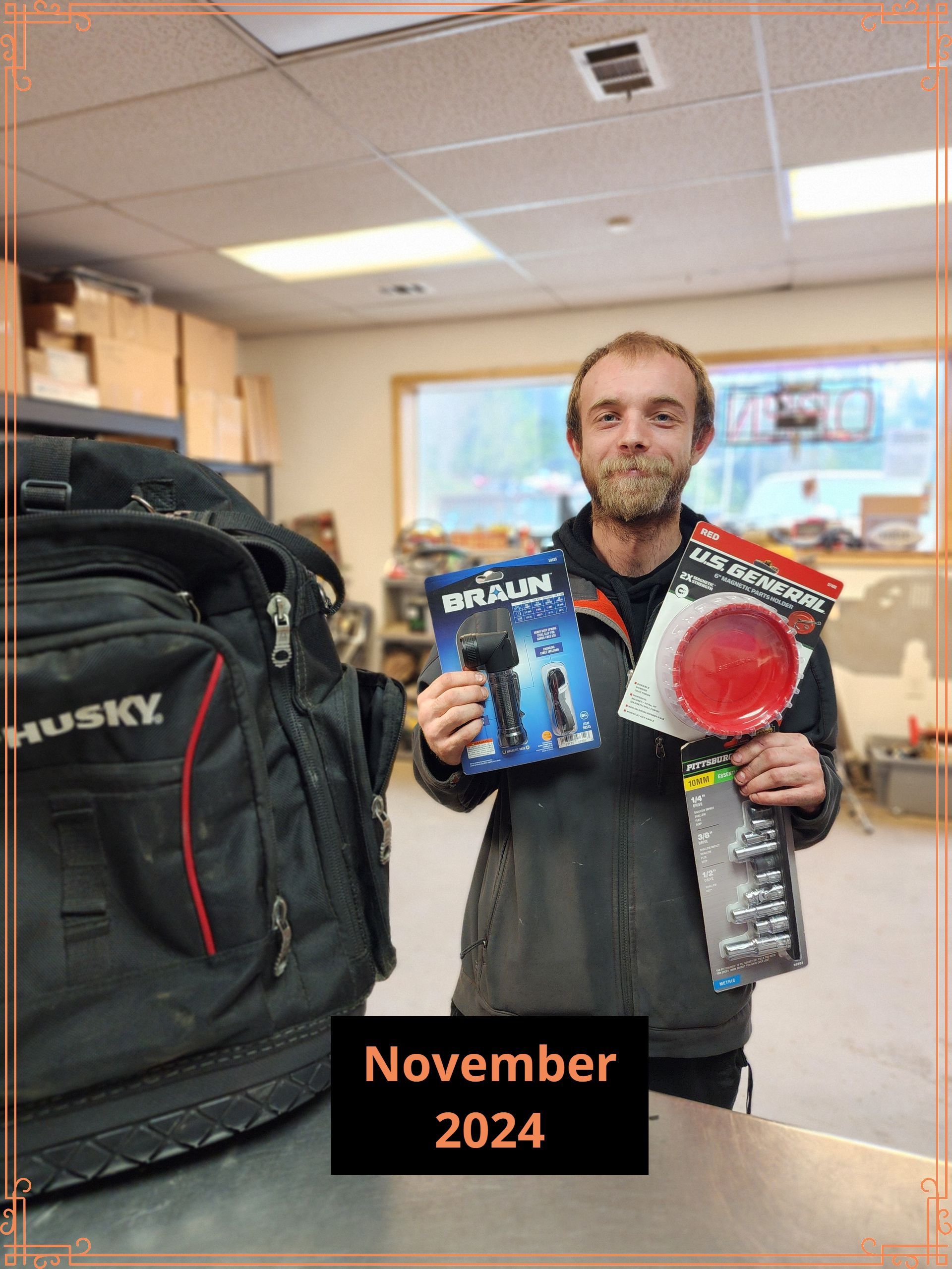 Man holding flashlight and lens, standing next to a Husky bag; indoors, November 2024.