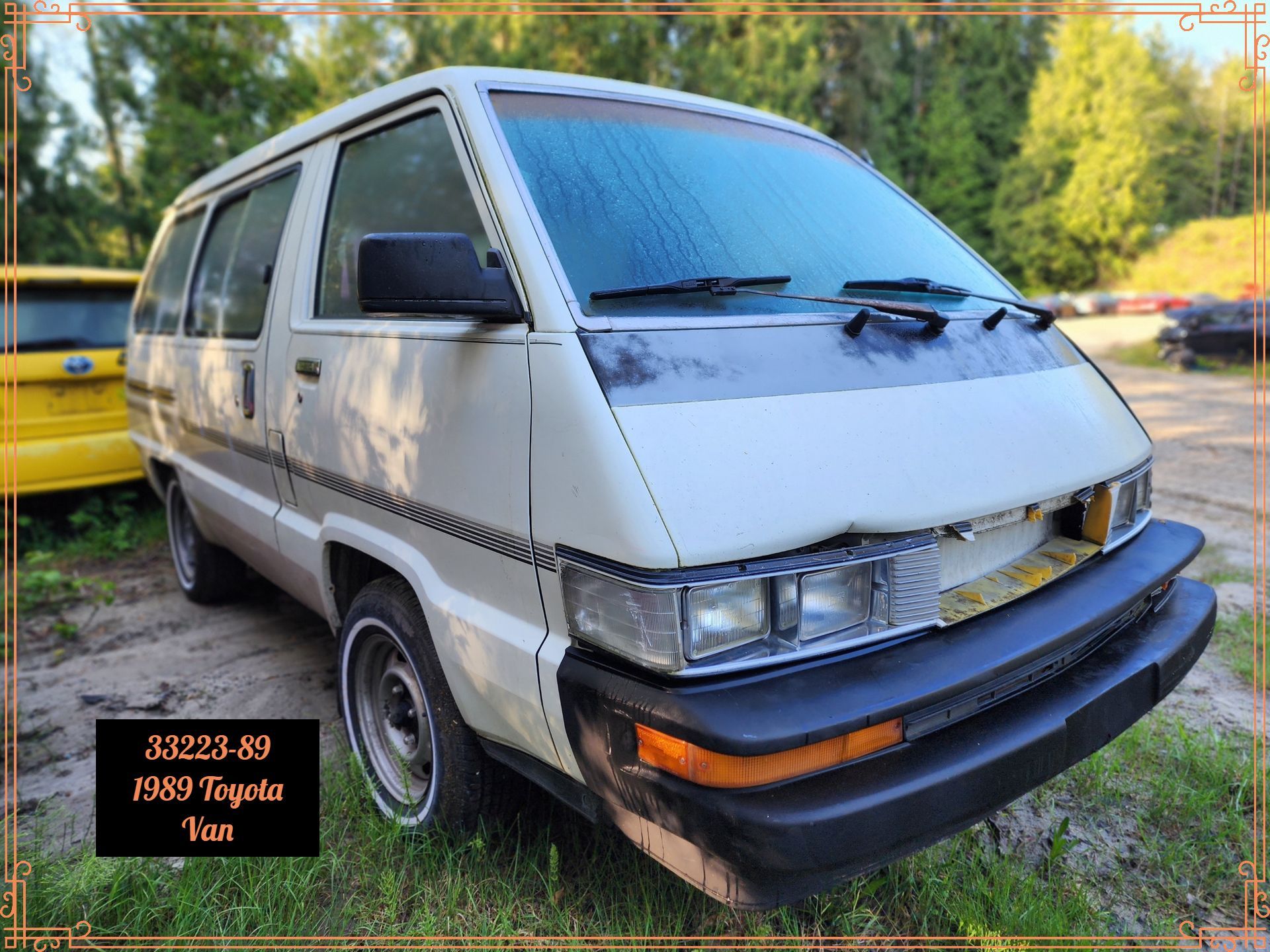 White Toyota van in a grassy area with trees.