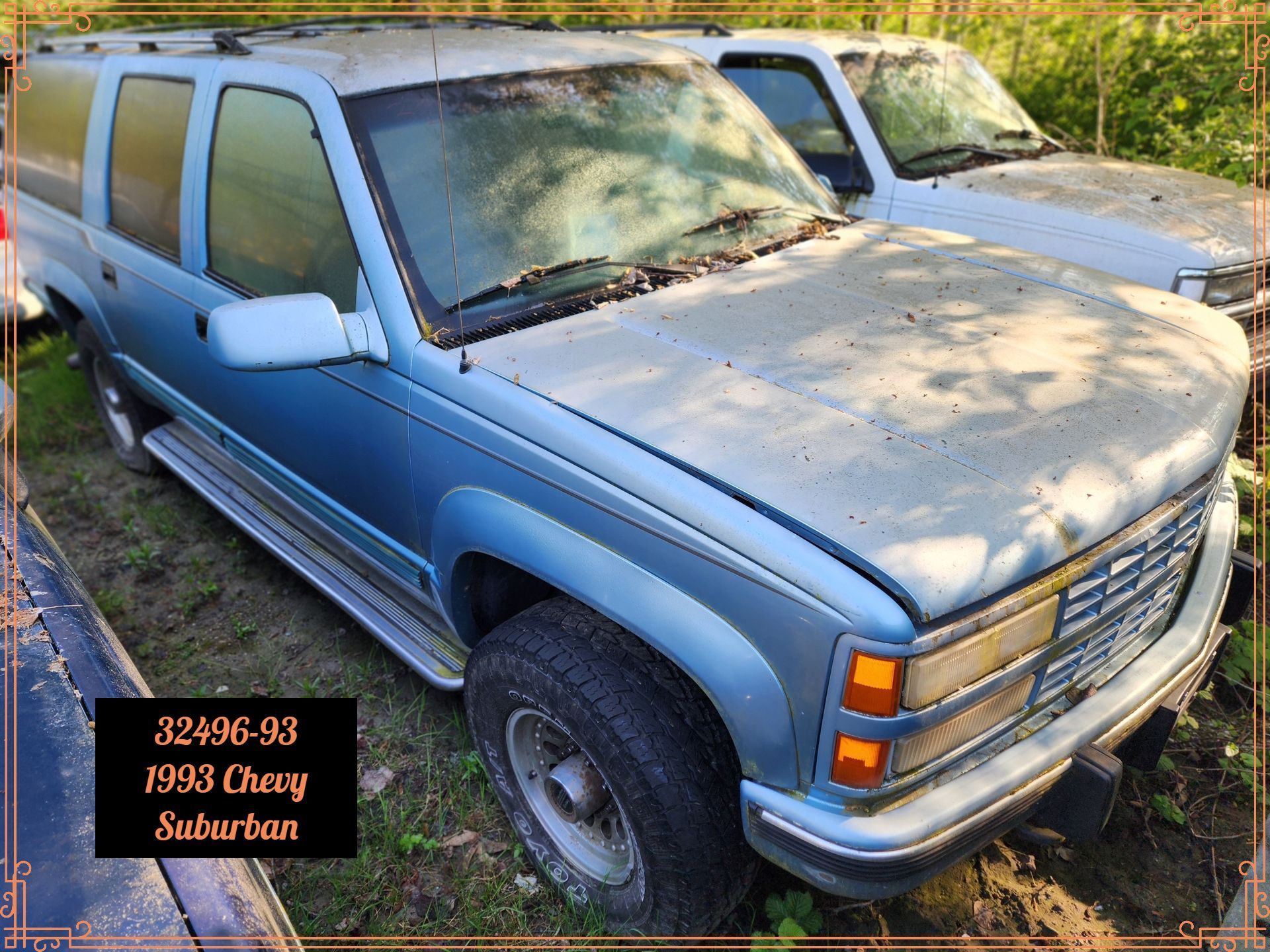 A weathered blue 1993 Chevrolet Suburban parked outside.