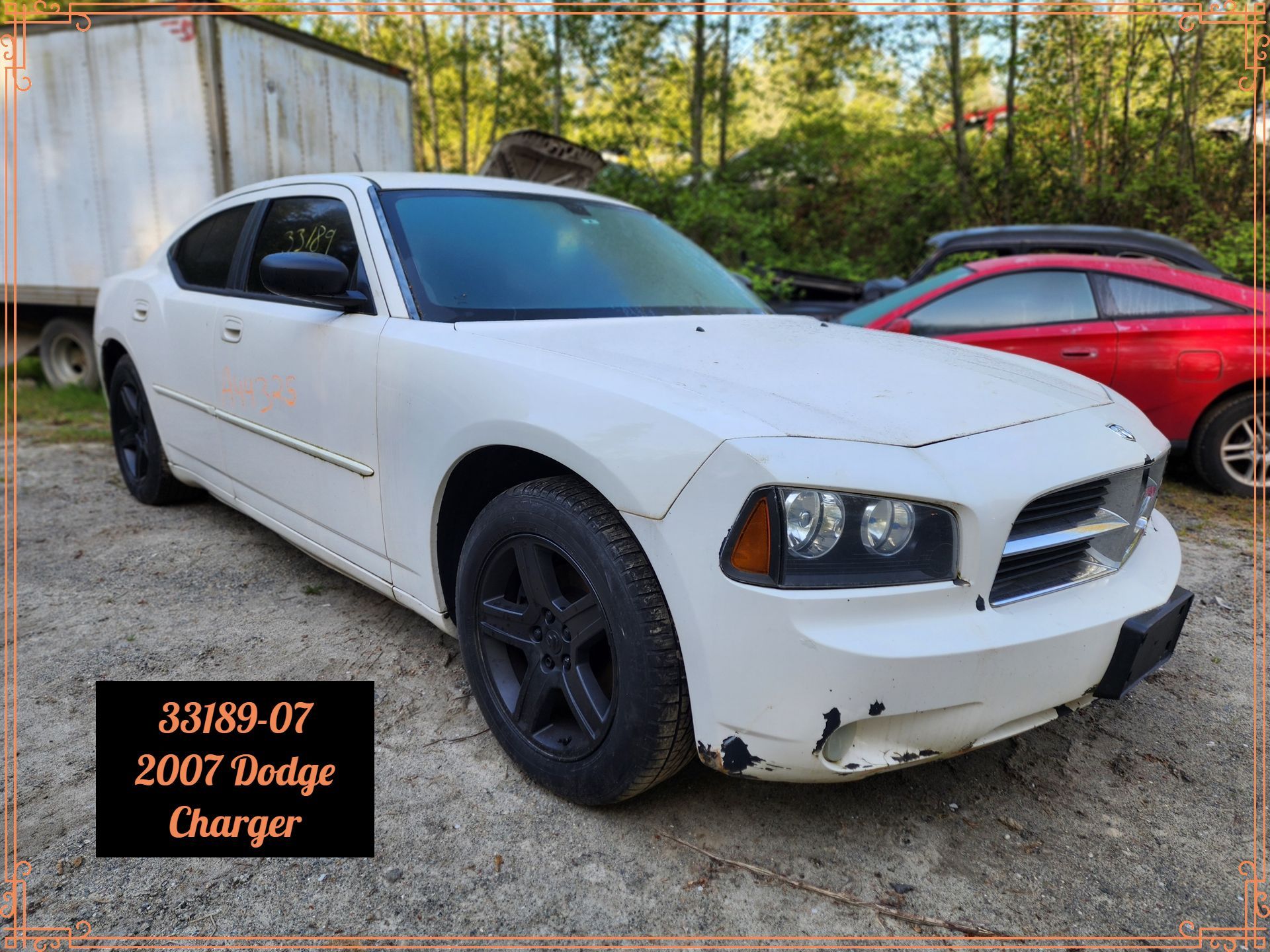 White 2007 Dodge Charger, black wheels, chipped paint on the front bumper, parked outside.