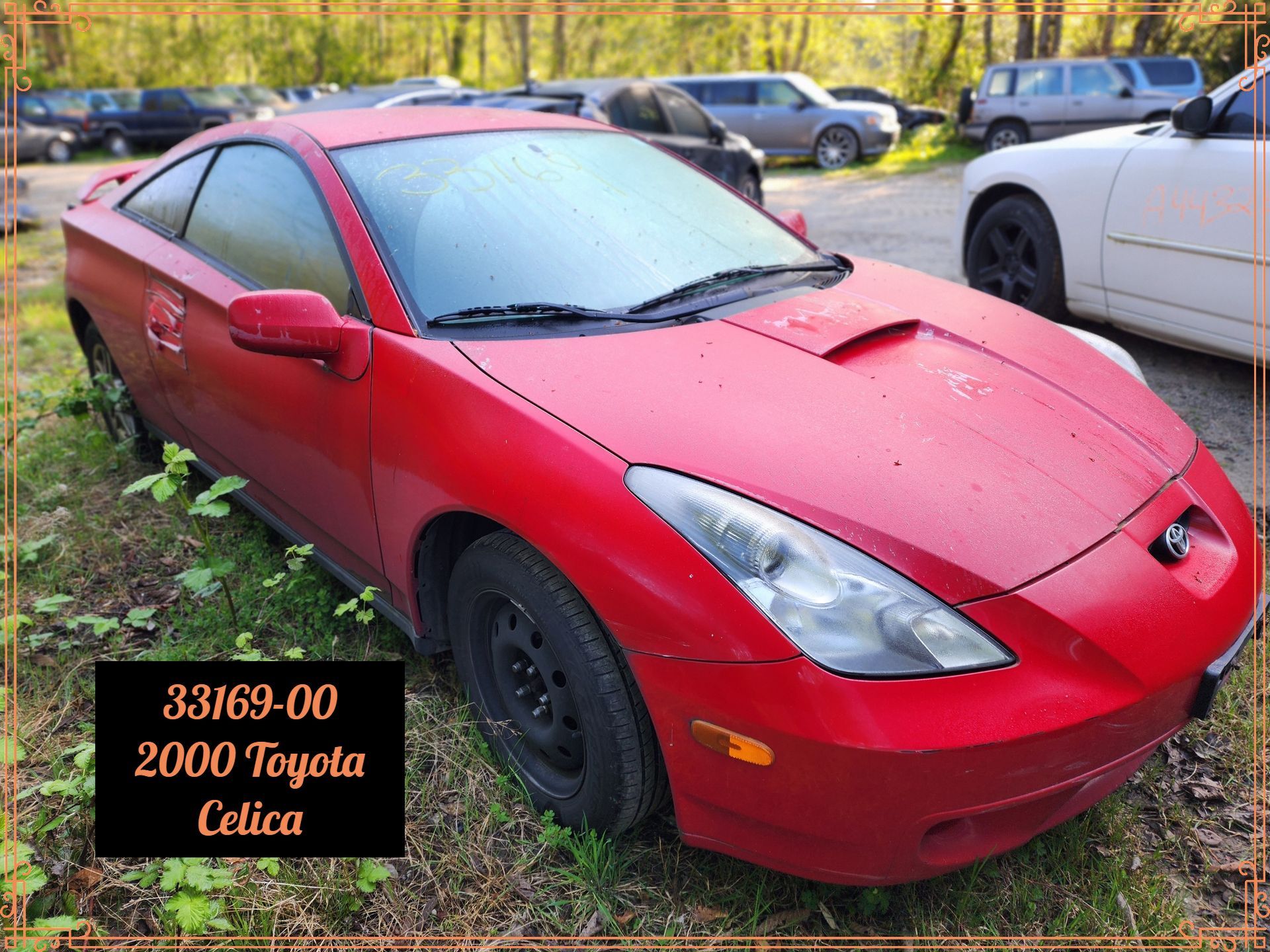 A red 2000 Toyota Celica car in a grassy area.