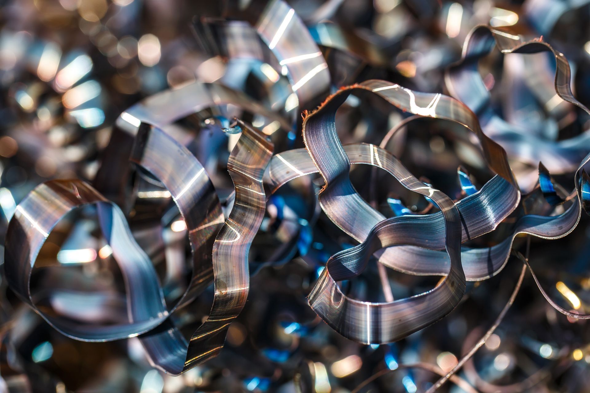 Curled strips of shiny metal shavings form a tangled pile ready for recycling.