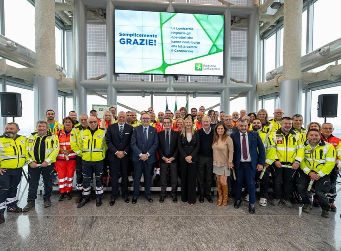 Trasporti ambulanza la Varesina Emergenza Varese parcheggiata accanto a una scogliera rocciosa con ghiaccio sospeso e vegetazione.