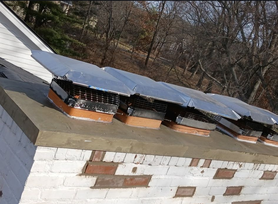 Multiple chimney caps installed on brick chimney to protect flues from water and animals in Cincinnati home