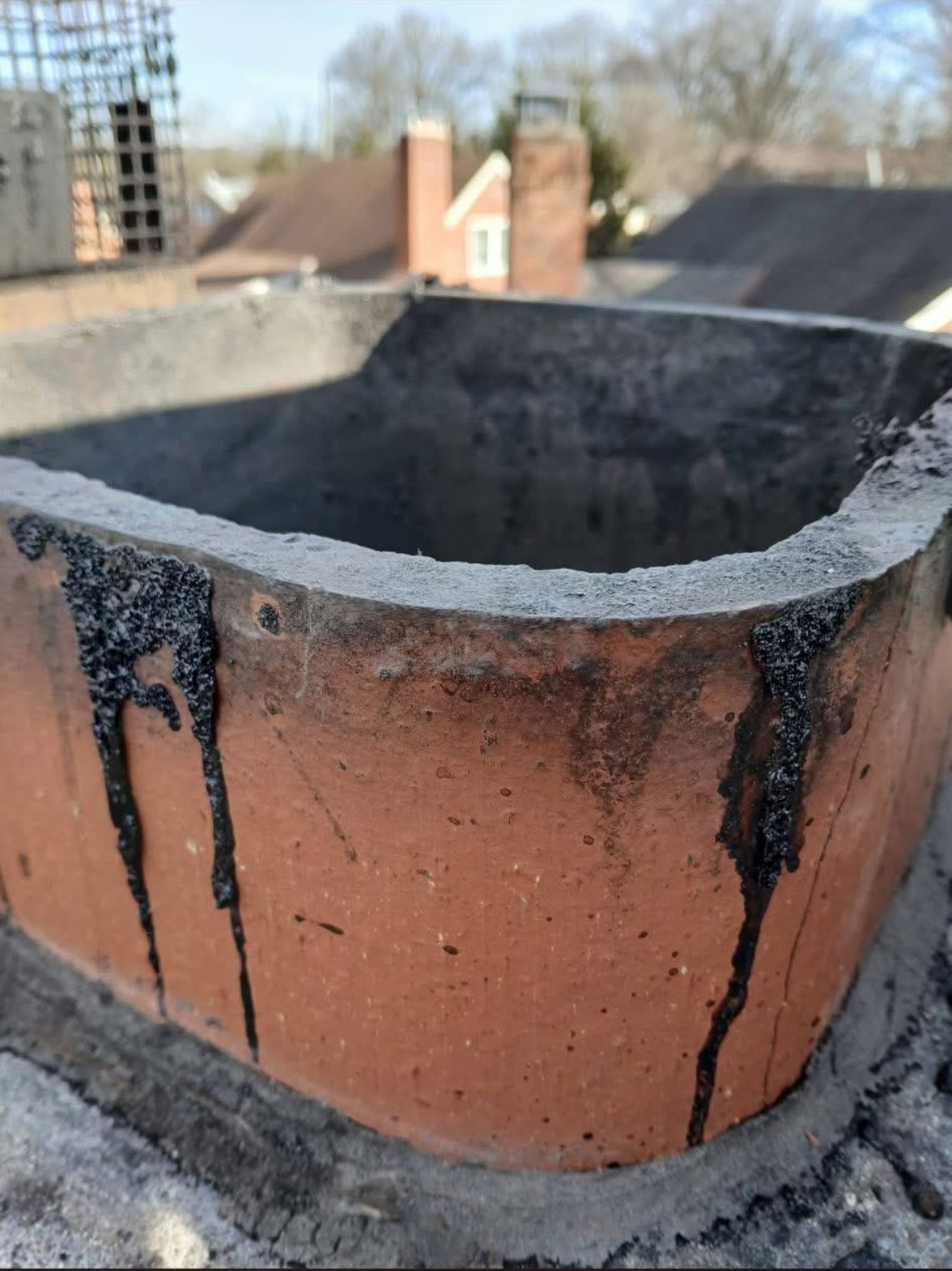 Clay chimney flue tile inspection showing wear and soot buildup inside masonry chimney