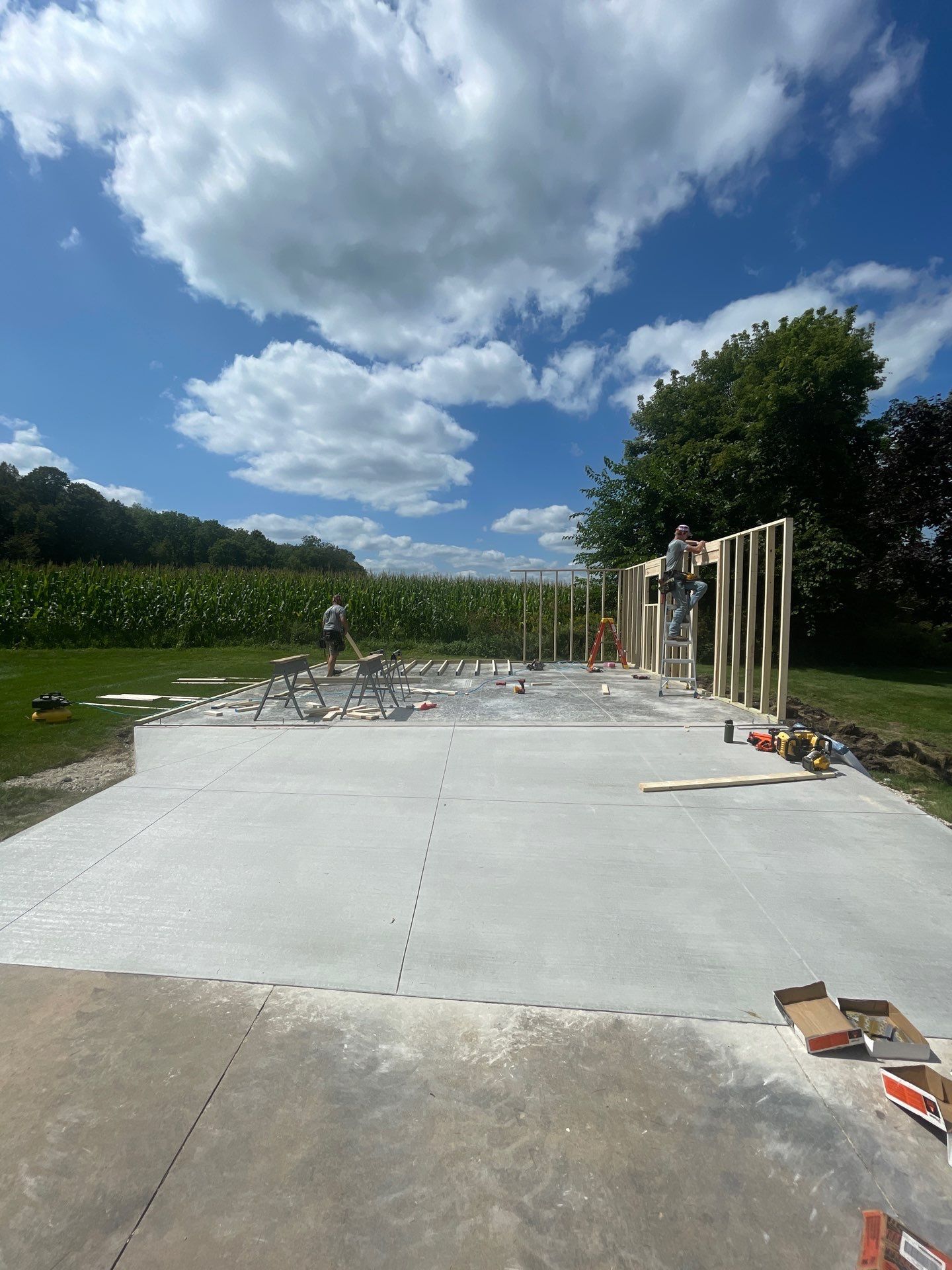 A concrete driveway is being built in a field.