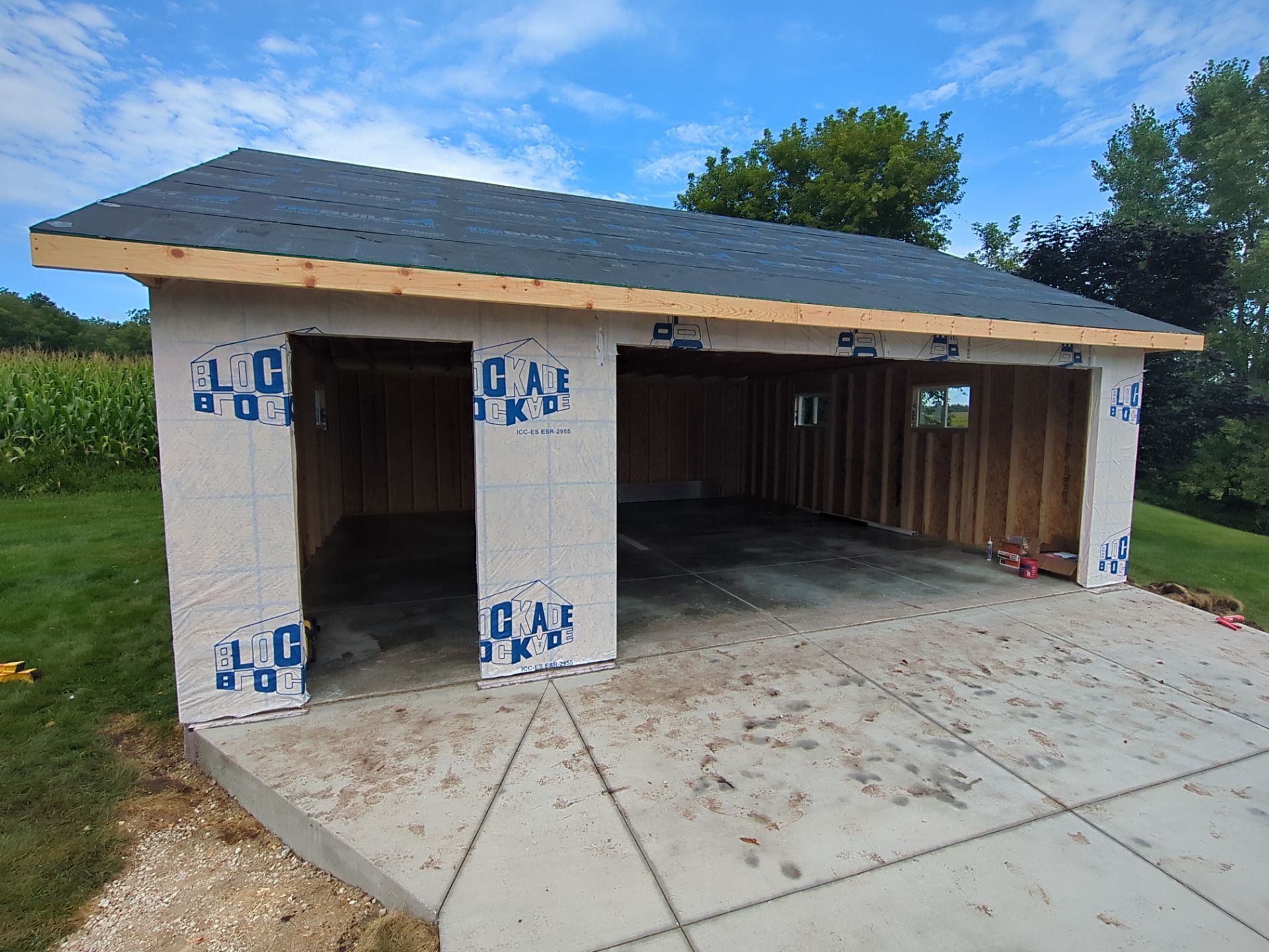 A garage is being built on a concrete driveway.