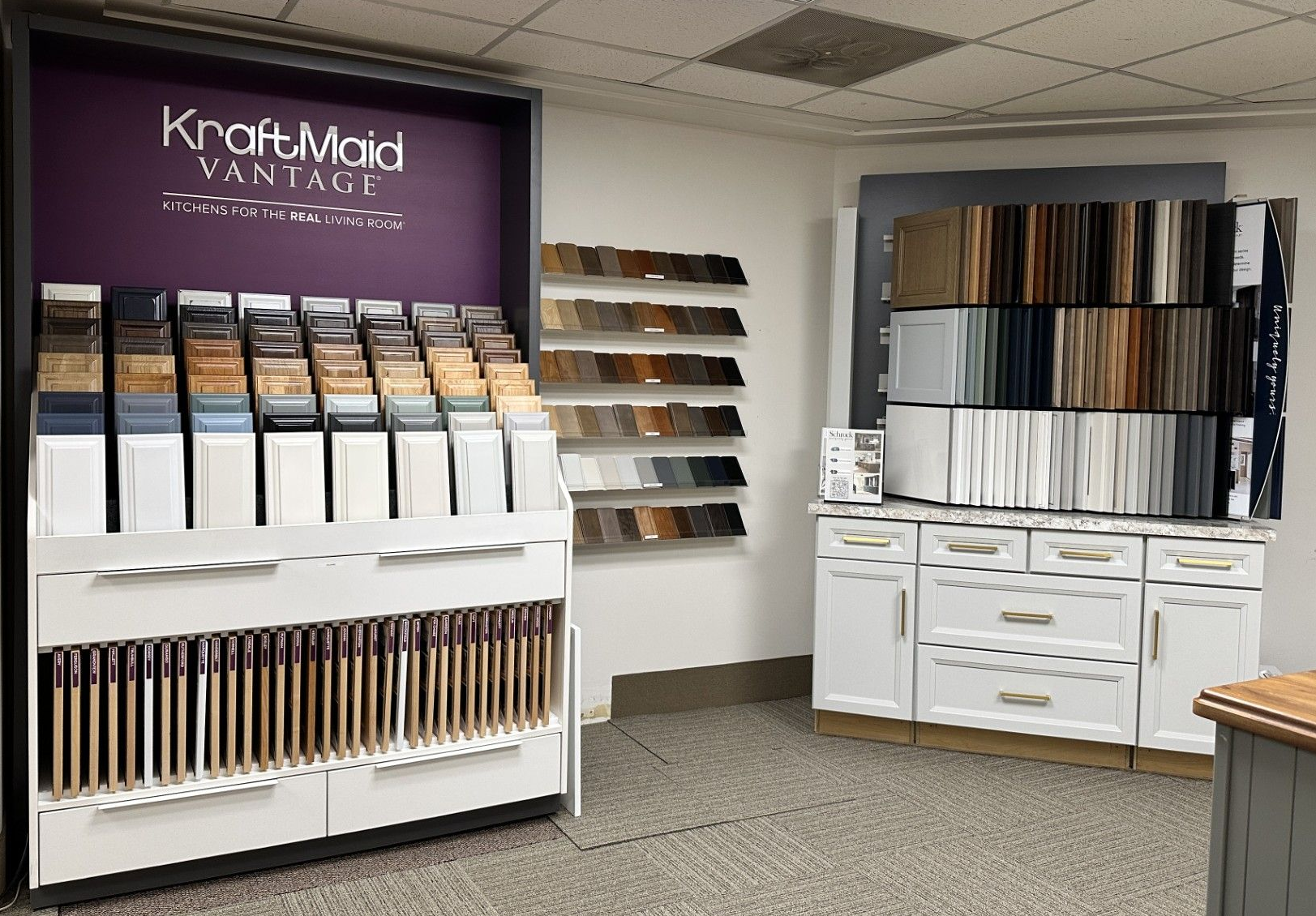 Kitchen cabinet display with various wood and paint samples.