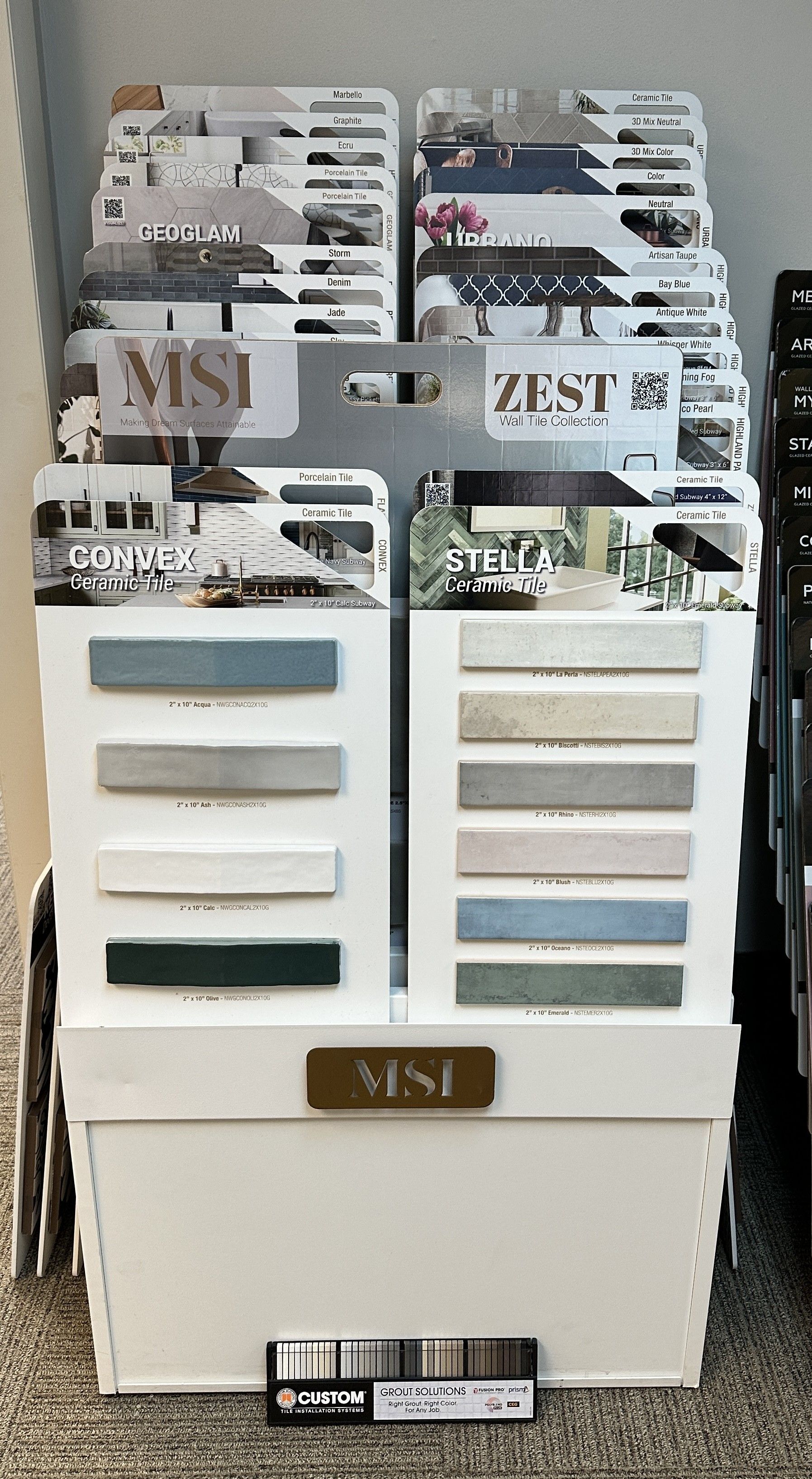 Display of MSI tile samples in a white bin, showing various colors and textures for design.