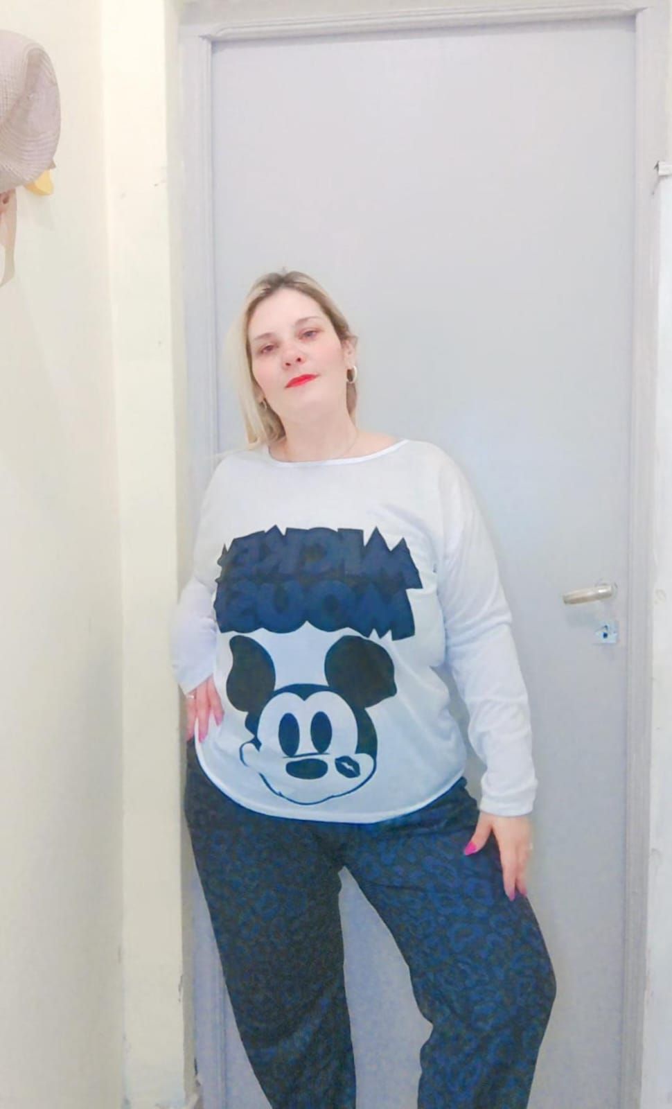 Mujer en pijama de Minnie Mouse de pie junto a una puerta cerrada.