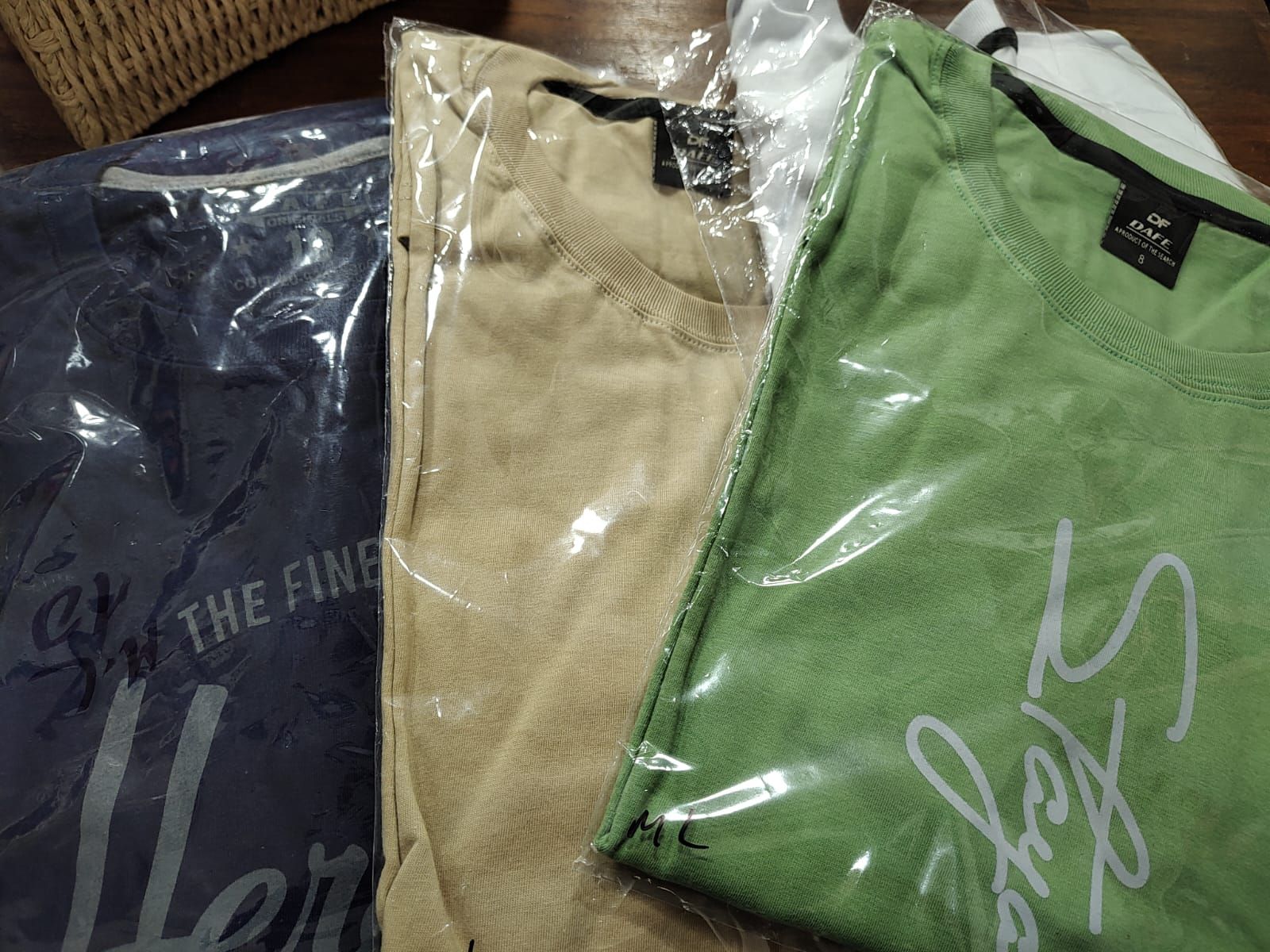 Un hombre con camisa azul claro y pantalones oscuros sonríe al aire libre.