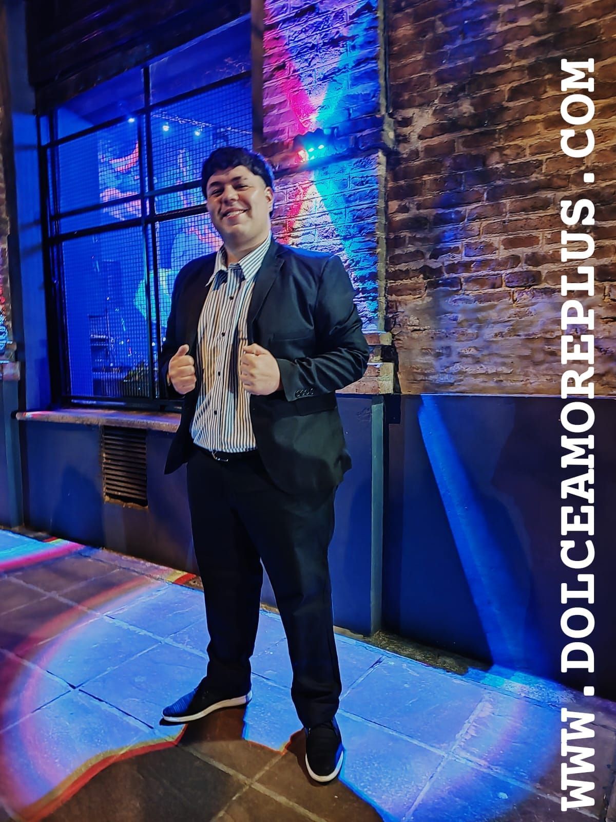 Un hombre con traje, con las manos en los bolsillos.